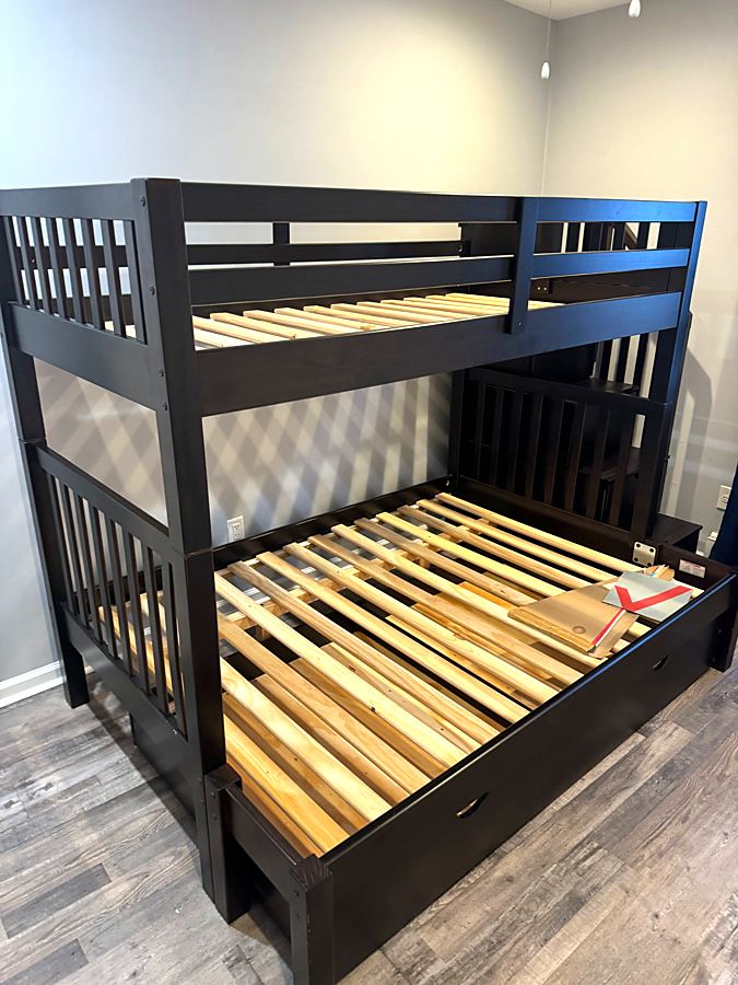 Assembled dark wood bunk bed with a lower full-size bed